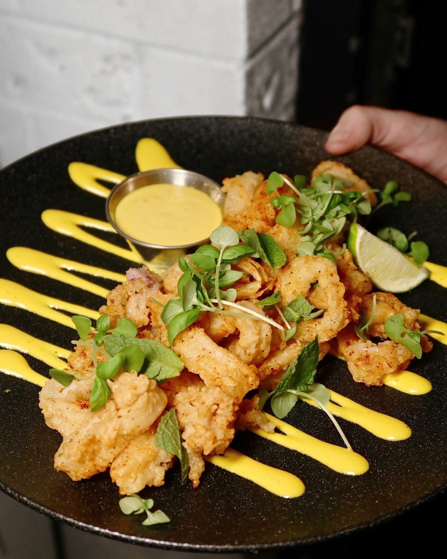 Fried calamari with aioli drizzle and lime at Somewhere Dine Bar